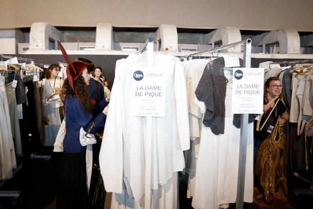 Customers browse through items for sale during a costume sale held by the Bastille Opera in Paris on May 29, 2026. The Opera Bastille is putting around 5,000 costumes for sale. (Photo by Kenzo TRIBOUILLARD / AFP)