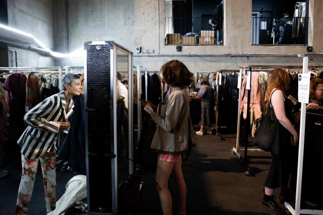 Customers browse through items for sale during a costume sale held by the Bastille Opera in Paris on May 29, 2026. The Opera Bastille is putting around 5,000 costumes for sale. (Photo by Kenzo TRIBOUILLARD / AFP)
