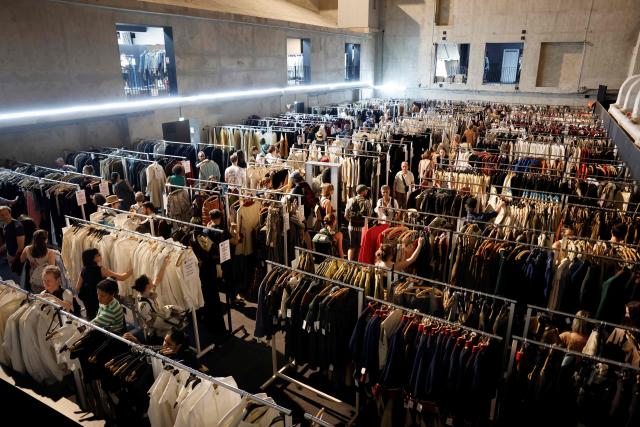 Customers browse through items for sale during a costume sale held by the Bastille Opera in Paris on May 29, 2026. The Opera Bastille is putting around 5,000 costumes for sale. (Photo by Kenzo TRIBOUILLARD / AFP)