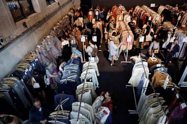 Customers browse through items for sale during a costume sale held by the Bastille Opera in Paris on May 29, 2026. The Opera Bastille is putting around 5,000 costumes for sale. (Photo by Kenzo TRIBOUILLARD / AFP)