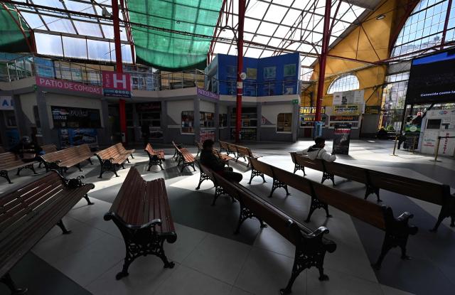 People sit inside the nearly empty La Paz Bus Terminal following the suspension of interdepartmental and international travel amid nationwide road blockades, in La Paz on May 29, 2026. (Photo by Aizar RALDES / AFP)