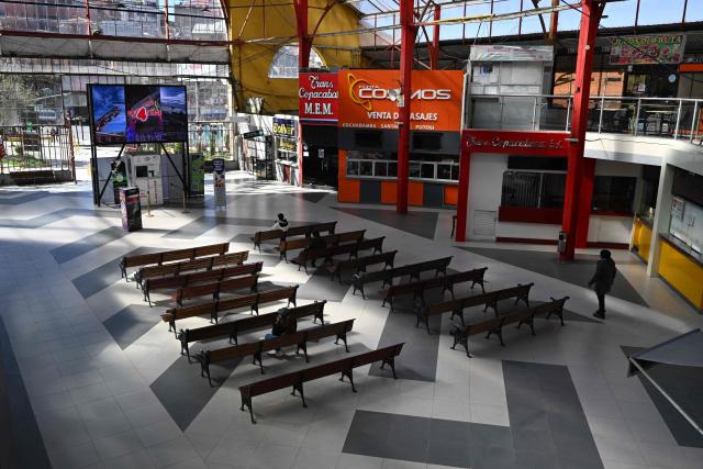 People sit and walk inside the nearly empty La Paz Bus Terminal following the suspension of interdepartmental and international travel amid nationwide road blockades, in La Paz on May 29, 2026. (Photo by Aizar RALDES / AFP)