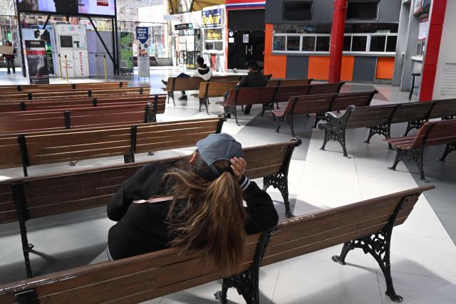 People sit inside the nearly empty La Paz Bus Terminal following the suspension of interdepartmental and international travel amid nationwide road blockades, in La Paz on May 29, 2026. (Photo by Aizar RALDES / AFP)
