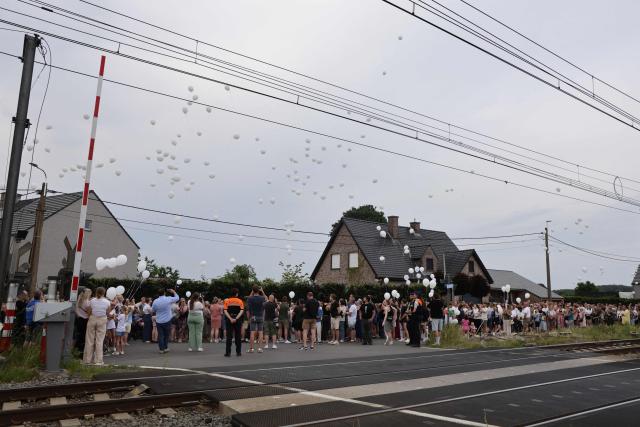 People release white balloons during a wake to commemorate the victims of an accident between a train and a school minibus at the railway crossing Vierhuizen in Buggenhout on May 29, 2026. A train on May 26, 2026 hit a school minibus killing four people, including two children in a "horrific accident" in northern Belgium, authorities said. The children aged 15 and 12, were killed by the impact alongside the 49-year-old driver and a 27-year-old supervisor, according to Lisa De Wilde, a spokeswoman for the prosecutor's office. (Photo by NICOLAS MAETERLINCK / Belga / AFP) / Belgium OUT