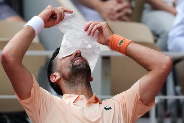 Serbia's Novak Djokovic tries to cool off while sitting in between games as he plays against Brazil's Joao Fonseca during their men's singles match on day 6 of the French Open tennis tournament on Court Philippe-Chatrier at the Roland-Garros Complex in Paris on May 29, 2026. (Photo by Dimitar DILKOFF / AFP)