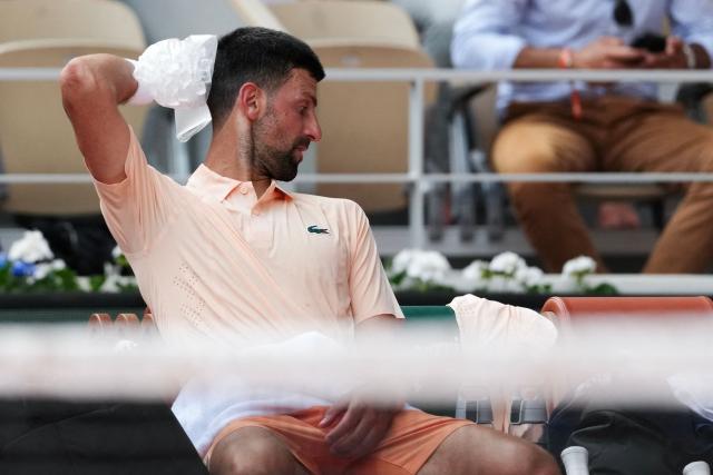 Serbia's Novak Djokovic tries to cool off while sitting in between games as he plays against Brazil's Joao Fonseca during their men's singles match on day 6 of the French Open tennis tournament on Court Philippe-Chatrier at the Roland-Garros Complex in Paris on May 29, 2026. (Photo by Dimitar DILKOFF / AFP)