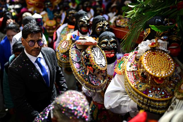 Members of a dance troupe (R) take part in the Lord of Choquekillka festival in Ollantaytambo, in the Cusco region of southern Peru, on May 24, 2026. The Lord of Choquekillka is the patron saint of Ollantaytambo, in the Cusco region, and the focus of a religious and cultural festival declared National Cultural Heritage. The main celebrations take place during Pentecost in May, blending Catholic devotion with ancestral dances, traditional music and Andean spiritual traditions. (Photo by ERNESTO BENAVIDES / AFP)