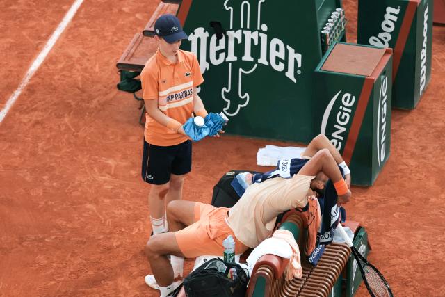 Serbia's Novak Djokovic stretches while sitting in between games as he plays against Brazil's Joao Fonseca during their men's singles match on day 6 of the French Open tennis tournament on Court Philippe-Chatrier at the Roland-Garros Complex in Paris on May 29, 2026. (Photo by Thomas SAMSON / AFP)