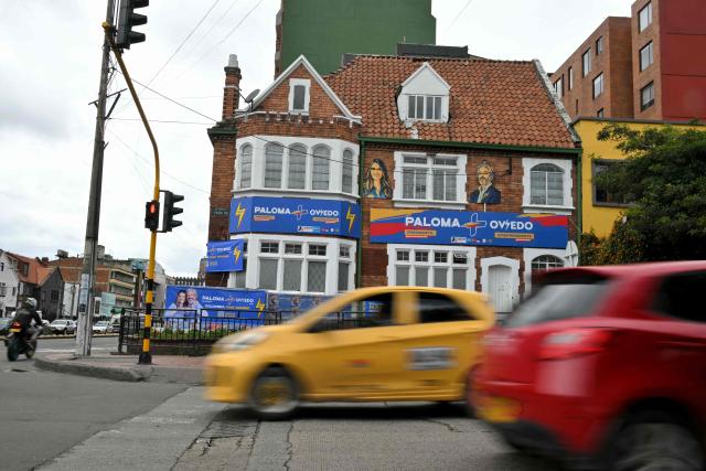 People drive past the campaign headquarters of Colombia's presidential candidate Paloma Valencia and vice-presidential candidate Juan Daniel Oviedo, from the Centro Democratico party, in Bogota on May 29, 2026. Colombia will hold presidential elections on May 31. (Photo by Rodrigo BUENDIA / AFP)