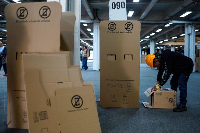 A worker prepares a polling station in Bogota, on May 29, 2026, ahead of the week-end's presidential election. (Photo by Sergio Acero / AFP)
