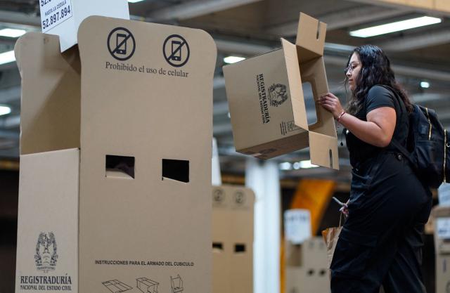 A worker prepares a polling station in Bogota, on May 29, 2026, ahead of the week-end's presidential election. (Photo by Sergio Acero / AFP)
