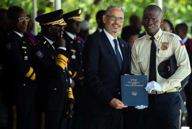 Haitian Prime Minister Alix Didier Fils-Aime poses for a photo with a new member of Haiti's National Police during a graduation ceremony at the Police Academy in Port-au-Prince, Haiti, on May 29, 2026. (Photo by Clarens SIFFROY / AFP)
