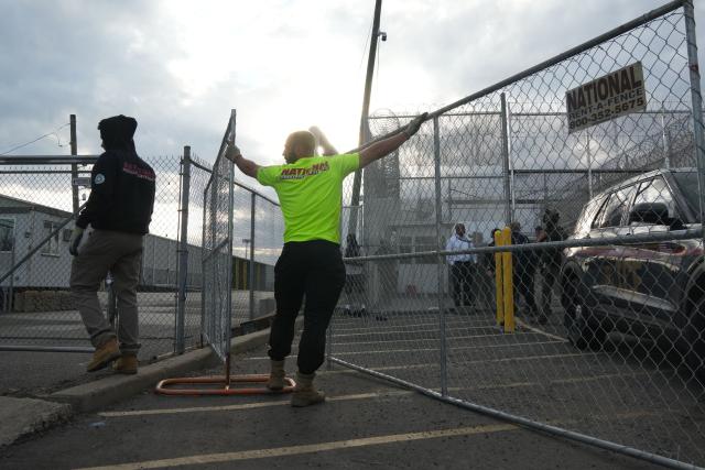 Contractors erect a fence at the federal immigration center at Delaney Hall, which is being used as an Immigration and Customs Enforcement (ICE) detention center, in Newark, New Jersey, on May 29, 2026. Protesters clashed with US law enforcement outside an immigration detention center in New Jersey, a top US official said Friday, after inmates inside staged a hunger strike over conditions. Days of unrest outside the ICE detention center have led to several arrests as a tough stance by US President Donald Trump's administration draws stiff opposition. (Photo by Bryan R. SMITH / AFP)