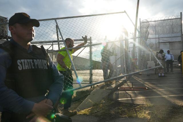 Contractors erect a fence at the federal immigration center at Delaney Hall, which is being used as an Immigration and Customs Enforcement (ICE) detention center, in Newark, New Jersey, on May 29, 2026. Protesters clashed with US law enforcement outside an immigration detention center in New Jersey, a top US official said Friday, after inmates inside staged a hunger strike over conditions. Days of unrest outside the ICE detention center have led to several arrests as a tough stance by US President Donald Trump's administration draws stiff opposition. (Photo by Bryan R. SMITH / AFP)