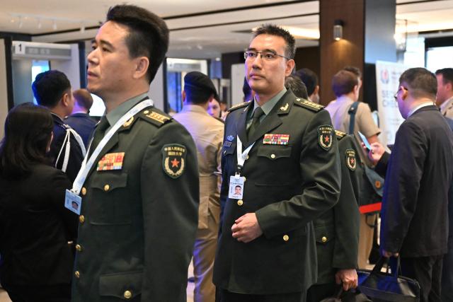 Lieutenant Colonel Zhang Chi (C), associate professor at the Chinese National Defence University's strategic advisory centre, arrives for the 23rd Shangri-La Dialogue summit in Singapore on May 30, 2026. (Photo by MOHD RASFAN / AFP)