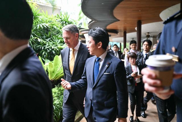 Australia's Defence Minister Richard Marles (centre, L) and Japan's Defense Minister Shinjiro Koizumi (centre, R) walk after the first plenary session of the 23rd Shangri-La Dialogue summit in Singapore on May 30, 2026. (Photo by MOHD RASFAN / AFP)