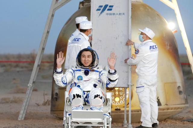 Shenzhou-21 astronaut Wu Fei waves after being carried from the Shenzhou-22 spacecraft after landing in China’s northern Inner Mongolia region on May 29, 2026. China's Shenzhou-21 crew returned to Earth aboard the Shenzhou-22 spacecraft on May 29 after seven months in space. (Photo by CNS / AFP) / China OUT