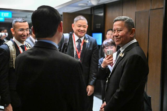 Thailand's Defence Minister Adul Boonthamcharoen (R) arrives for a ministerial roundtable during the 23rd Shangri-La Dialogue summit in Singapore on May 30, 2026. (Photo by MOHD RASFAN / AFP)