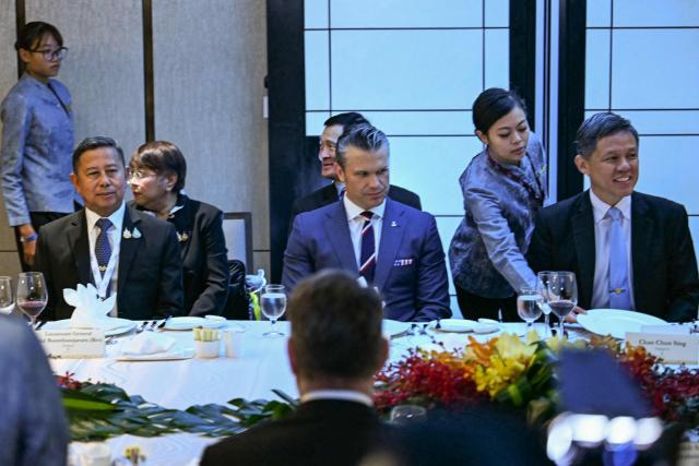 US Secretary of Defence Pete Hegseth (C), Thailand's Defence Minister Adul Boonthamcharoen (L), and Singapore's Minister of Defence Chan Chun Sing attend a ministerial roundtable during the 23rd Shangri-La Dialogue summit in Singapore on May 30, 2026. (Photo by MOHD RASFAN / AFP)