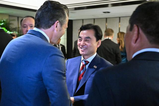 US Secretary of Defence Pete Hegseth (L) shakes hands with South Korea's Minister of National Defense Ahn Gyu-back as they arrive for a ministerial roundtable during the 23rd Shangri-La Dialogue summit in Singapore on May 30, 2026. (Photo by MOHD RASFAN / AFP)