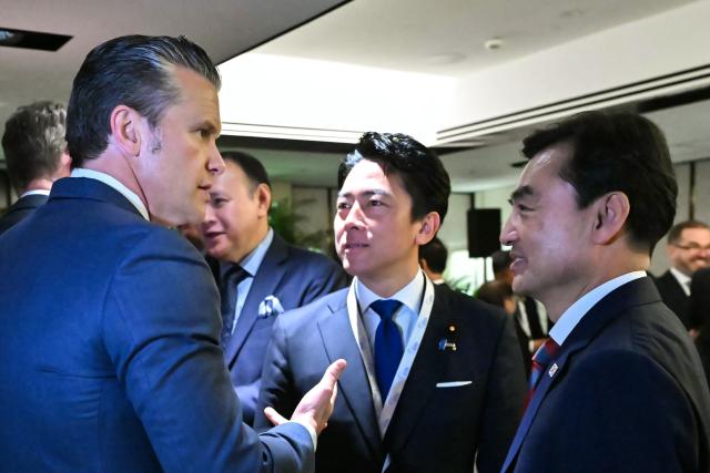 US Secretary of Defence Pete Hegseth (L) speaks with South Korea's Minister of National Defense Ahn Gyu-back (R) and Japan's Defense Minister Shinjiro Koizumi as they arrive for a ministerial roundtable during the 23rd Shangri-La Dialogue summit in Singapore on May 30, 2026. (Photo by MOHD RASFAN / AFP)