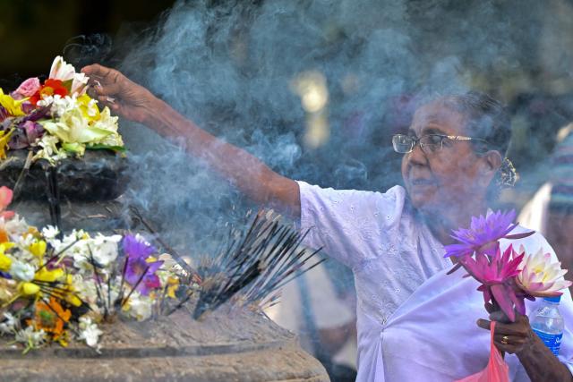 A devotee holding lotus flowers visits the Kelaniya Buddhist Temple to mark the 'Vesak festival' that commemorates the birth, the enlightenment, and the death of Buddha in Kelaniya on May 30, 2026. (Photo by Ishara S. KODIKARA / AFP)