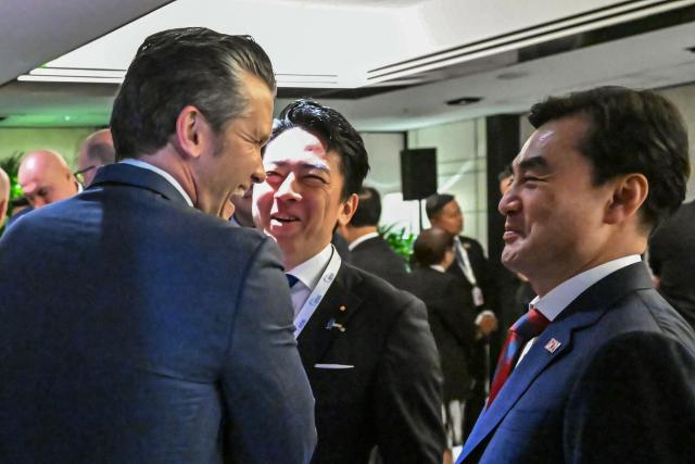 US Secretary of Defence Pete Hegseth (L) speaks with South Korea's Minister of National Defense Ahn Gyu-back (R) and Japan's Defense Minister Shinjiro Koizumi as they arrive for a ministerial roundtable during the 23rd Shangri-La Dialogue summit in Singapore on May 30, 2026. (Photo by MOHD RASFAN / AFP)