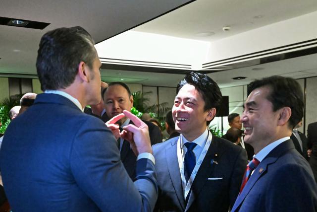 US Secretary of Defence Pete Hegseth (L) speaks with South Korea's Minister of National Defense Ahn Gyu-back (R) and Japan's Defense Minister Shinjiro Koizumi as they arrive for a ministerial roundtable during the 23rd Shangri-La Dialogue summit in Singapore on May 30, 2026. (Photo by MOHD RASFAN / AFP)