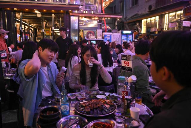 Customers eat at a Korean barbecue restaurant in Seoul on May 30, 2026. (Photo by Pedro PARDO / AFP)