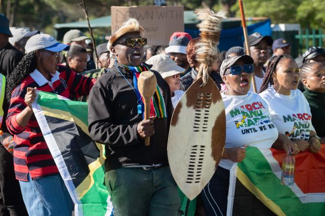 A group of people, many carrying sticks and clubs, take part in a protest against illegal immigrants organised by March and March in Goodwood, a Cape Town suburb, on May 30, 2026. (Photo by RODGER BOSCH / AFP)