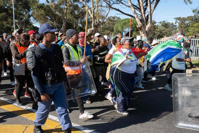 A group of people, many carrying sticks and clubs, take part in a protest against illegal immigrants organised by March and March in Goodwood, a Cape Town suburb, on May 30, 2026. (Photo by RODGER BOSCH / AFP)