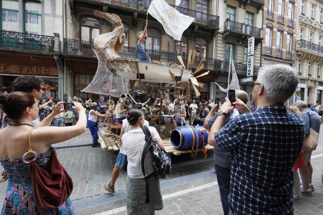 People watch participants take part in the 14th edition of the 'Zinneke Parade' in Brussels on May 30, 2026. The multicultural carnival and community-led parade weaves through Brussels with towering costumes, street theatre and live music — created in 2000 by artists and neighbourhood collectives, celebrating the city's cultural mix in a joyful, irreverent procession held every two years. (Photo by NICOLAS MAETERLINCK / Belga / AFP) / Belgium OUT