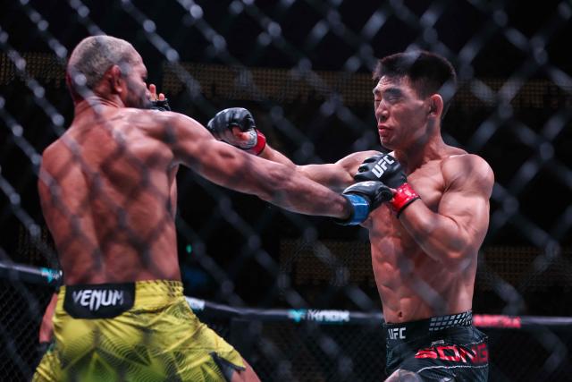 China’s bantamweight fighter Song Yadong (R) punches his opponent Brazil’s Deiveson Figueiredo during their bout at the UFC Fight Night in Galaxy hotel resort, Macau on May 30, 2026. (Photo by Eduardo Leal / AFP)