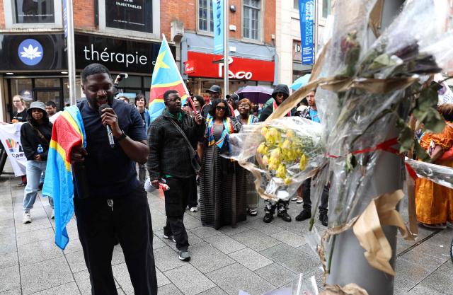Dublin-based producer and musician Chris Kabs stops at a memorial on Henry Street during a protest in central Dublin, to demand justice following the death of Democratic Republic of the Congo citizen Yves Sakila, after he was violently restrained by shop security guards who suspected him of shoplifting, on May 30, 2026. (Photo by Damien Eagers / AFP)