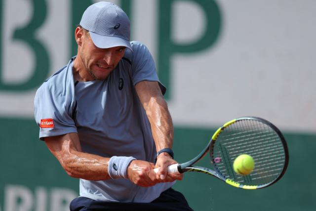 Belgium's Raphael Collignon plays a backhand return to Italy's Matteo Arnaldi during their men's singles match on day 7 of the French Open tennis tournament at the Roland-Garros Complex in Paris on May 30, 2026. (Photo by Thomas SAMSON / AFP)