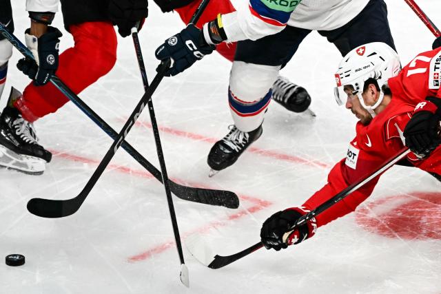 Switzerland's forward #17 Ken Jager (R) fights for the puck during the IIHF Ice Hockey Men's World Championship semi-final match between Switzerland and Norway at the Swiss Life Arena in Zurich, on May 30, 2026. (Photo by Fabrice COFFRINI / AFP)