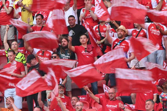 Fans wave flags before the UEFA Champions League final football match between Paris Saint-Germain (PSG) and Arsenal FC at the Puskas Arena in Budapest on May 30, 2026. (Photo by Antonin THUILLIER / AFP)