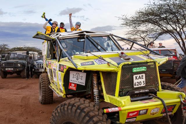 Members of Team Loafer react to cheers as they leave for their team's starting point at dawn at the start of the Rhino Charge 2026 competition at Ngilai community conservancy in Samburu county on May 30, 2026. The Rhino Charge is an annual bush-bashing competition that attracts extreme off-roading enthusiasts who navigate designated sections of uncharted wilderness in specially self-modified vehicles to raise funds for the conservation of Kenya's water towers.Since its inception in 1989, the Rhino Charge has raised over KES 2.6 billion (approximately $20 million USD) that has been used to construct and maintain some 853 kilometres of protective fences around the country's main water catchments that safeguard indigenous forest and certain threatened species residing therein. (Photo by Tony KARUMBA / AFP)