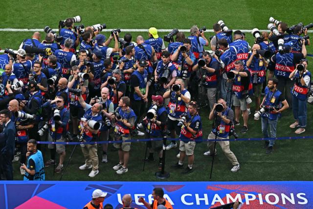 Photographers work during the opening ceremony of the UEFA Champions League final football match between Paris Saint-Germain (PSG) and Arsenal FC at the Puskas Arena in Budapest on May 30, 2026. (Photo by Attila KISBENEDEK / AFP)