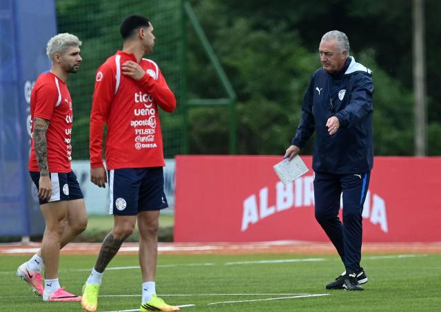 Paraguay's Argentine head coach Gustavo Alfaro speaks with Paraguay's forward Julio Enciso (L) and Paraguay's midfielder Hernesto Caballero during a training session at the High-Performance Center (CARDE) ahead of the friendly farewell match against Nicaragua with a view to the 2026 FIFA World Cup, in Ypane, Paraguay on May 30, 2026. (Photo by DANIEL DUARTE / AFP)
