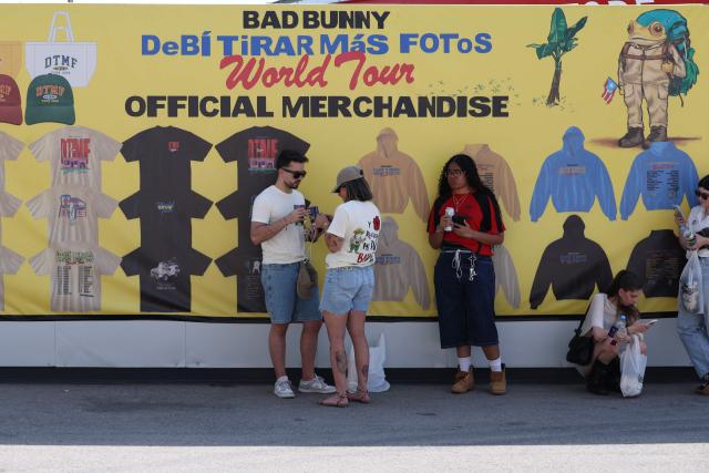 Fans queue in front of a promotional sign for Bad Bunny's 'Debi tirar mas fotos' World Tour outside the Metropolitano stadium, ahead of his first concert in Madrid later tonight on May 30, 2026. The Puerto Rican superstar kicks off a series of ten concerts in Madrid today, underscoring the Spanish capital’s rapid rise as Europe’s new hub for Latin sounds. Colombian pop superstar Shakira will follow with a 12-night residency beginning September 18 at a temporary venue under construction in southern Madrid that will hold roughly 50,000 people. (Photo by Thomas COEX / AFP)