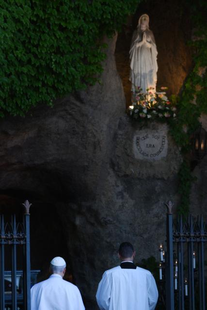 Pope Leo XIV (L) prays at the replica of the Lourdes Grotto in the Vatican's Gardens during the celebration of a rosary event marking the closing of the Marian month, in The Vatican on May 30, 2026. (Photo by TIZIANA FABI / AFP)