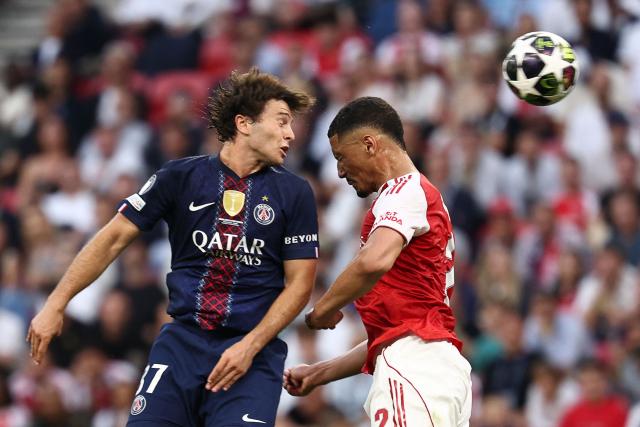Paris Saint-Germain's Portuguese midfielder #87 Joao Neves (L) and France's defender #17 William Saliba jump for the ball during the UEFA Champions League final football match between Paris Saint-Germain (PSG) and Arsenal FC at the Puskas Arena in Budapest on May 30, 2026. (Photo by FRANCK FIFE / AFP)