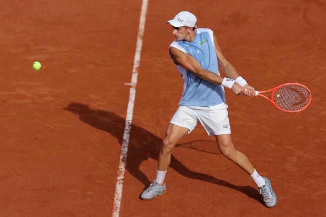 Italy's Matteo Arnaldi plays a backhand return to Belgium's Raphael Collignon during their men's singles match on day 7 of the French Open tennis tournament at the Roland-Garros Complex in Paris on May 30, 2026. (Photo by Thomas SAMSON / AFP)