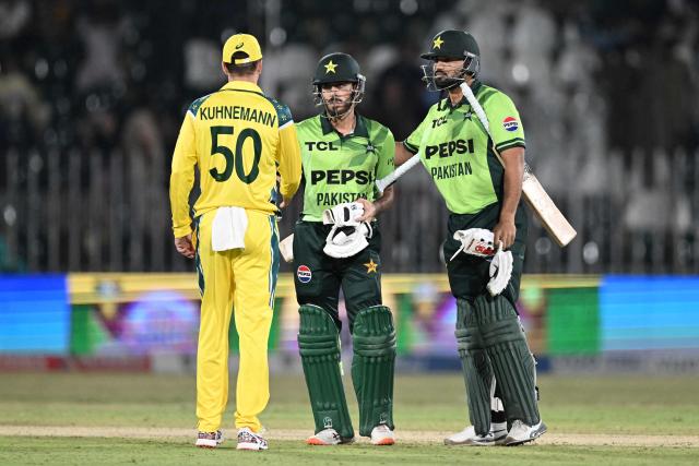 Pakistan's Abdul Samad (R) and teammate Arafat Minhas (C) shake hand with Australia's Matthew Kuhnemann at the end of  the first one-day international (ODI) cricket match between Pakistan and Australia at the Rawalpindi Cricket Stadium in Rawalpindi on May 30, 2026.  (Photo by Aamir QURESHI / AFP)