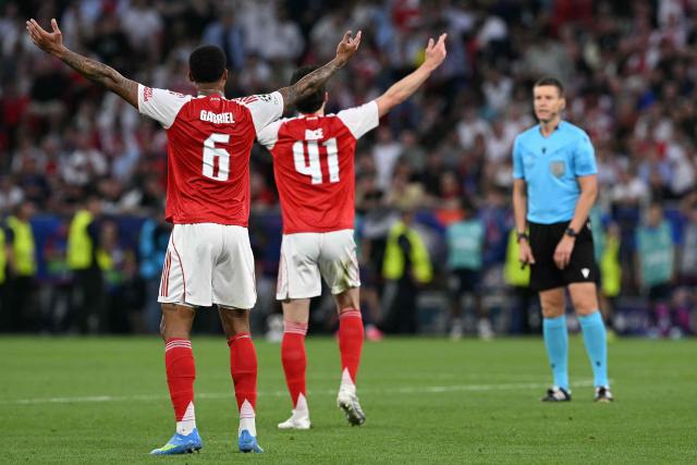 Arsenal's Brazilian defender #06 Gabriel Magalhaes (L) and Arsenal's English midfielder #41 Declan Rice (C) react after a decision by German referee Daniel Siebert (R) during the UEFA Champions League final football match between Paris Saint-Germain (PSG) and Arsenal FC at the Puskas Arena in Budapest on May 30, 2026. (Photo by NICOLAS TUCAT / AFP)
