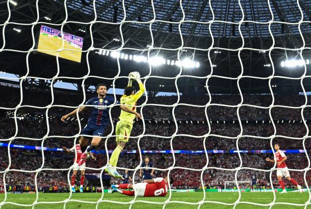 Arsenal's Spanish goalkeeper #01 David Raya (C) saves the ball as he vies with Paris Saint-Germain's Brazilian defender #04 Lucas Beraldo (L) during the UEFA Champions League final football match between Paris Saint-Germain (PSG) and Arsenal FC at the Puskas Arena in Budapest on May 30, 2026. (Photo by Ina FASSBENDER / AFP)