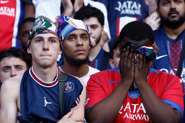 Paris Saint-Germain's supporters react during the UEFA Champions League final football match between Paris Saint-Germain (PSG) and Arsenal FC played in Budapest, displayed on a giant screen at the Parc des Princes stadium fan zone, in Paris on May 30, 2026. (Photo by Kenzo TRIBOUILLARD / AFP)