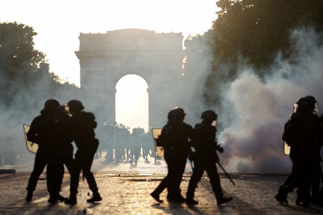 French Republican Security Corps (CRS - Compagnies Republicaines de Securite) Police officers walk amid smoke from teargas on the Champs-Elysees Avenue, during the UEFA Champions League final football match between Paris Saint-Germain (PSG) and Arsenal FC played in Budapest, in Paris on May 30, 2026. (Photo by ROMEO BOETZLE / AFP)