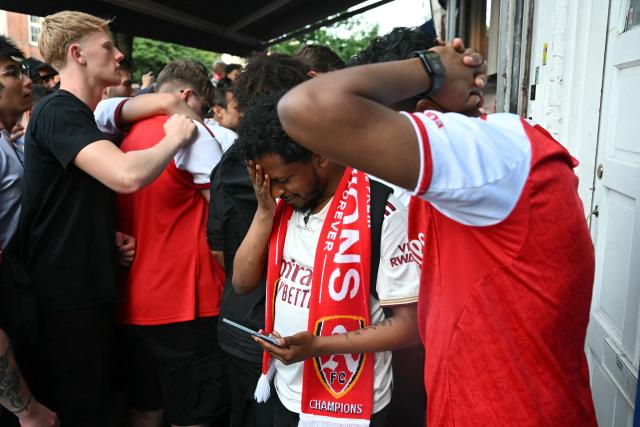 Arsenal fans react as they watch the penalty shoot-out near to Arsenal's ground during the UEFA Champions League Final against Paris Saint-Germain, in London on May 30, 2026. (Photo by JUSTIN TALLIS / AFP)